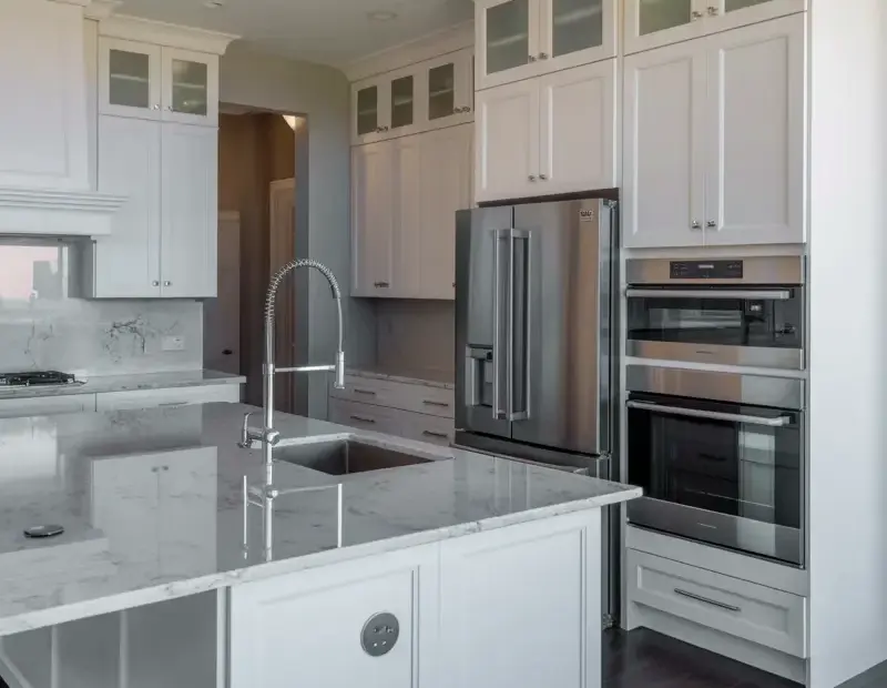 Modern luxury kitchen with white shaker cabinets and marble island design